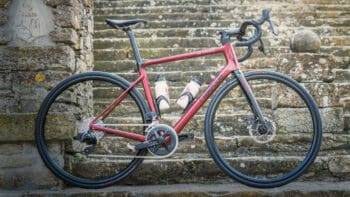 Red Italy bike tour racing bicycle with water bottles on a stone staircase in Italy.