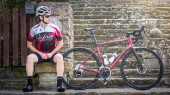 High-performance road bike with water bottles and advanced gear, resting against historic stone steps in Italy, perfect for scenic bike tours through Italy's landscapes and road biking adventures.