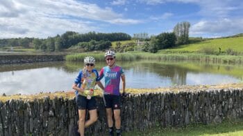 Beautiful cycling duo enjoying a scenic ride along the lush greenery and tranquil water in Italy, perfect for bike tours and exploring Italy's picturesque landscapes.