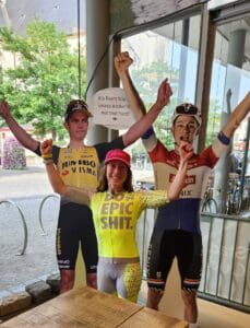 Bright indoor scene with enthusiastic cyclists celebrating, featuring Italy bike tours, vibrant jerseys, and a cheerful atmosphere.