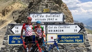 Bikers at Col du Galibier mountain pass in the French Alps during an Italy bike tour, enjoying scenic views and challenging climbs on competitive cycling routes.