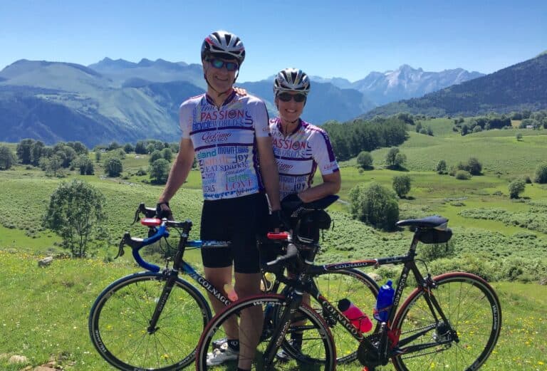 Vibrant cycling duo enjoying scenic Italy mountain landscape with professional bikes during classic bike tour.
