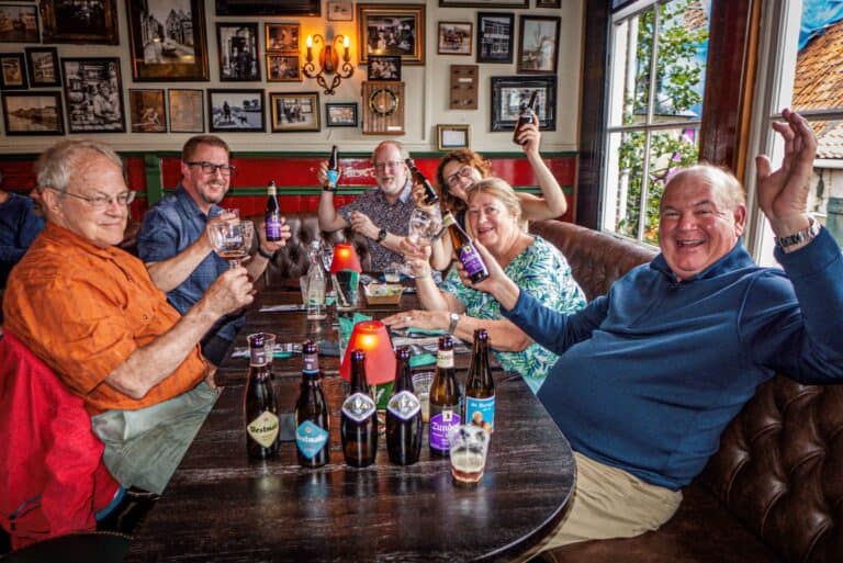 Cheerful group of cyclists enjoying drinks at a cozy Italian cafe after a bike tour in Italy.