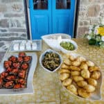 Traditional Italian antipasti and snacks served on a dining table with a rustic stone wall background, perfect for Italy bike tours by Ciclismo Classico.