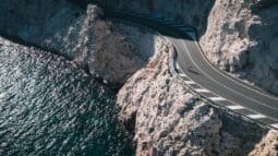 Spectacular coastal Italy bike route along cliffs with sharp turns and panoramic ocean views, perfect for cycling enthusiasts exploring Italy by bike.