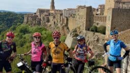 Group of cyclists enjoying a guided bike tour through historic Italian towns with scenic views and ancient architecture, perfect for cycling enthusiasts exploring Italy.