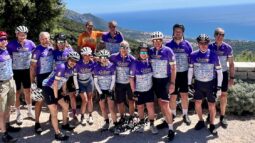 Group of cyclists enjoying a scenic ride along the Italian coast with stunning ocean views and lush landscapes, highlighting Italy's best biking routes and cycling experiences.